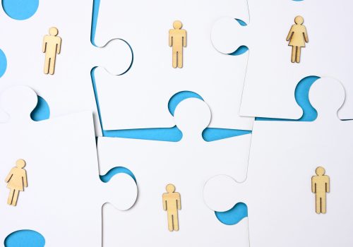 white puzzles and wooden men. Recruitment concept, team compatibility, individuality of each